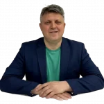Александр Макаров, медицинский психолог, улыбается за столом