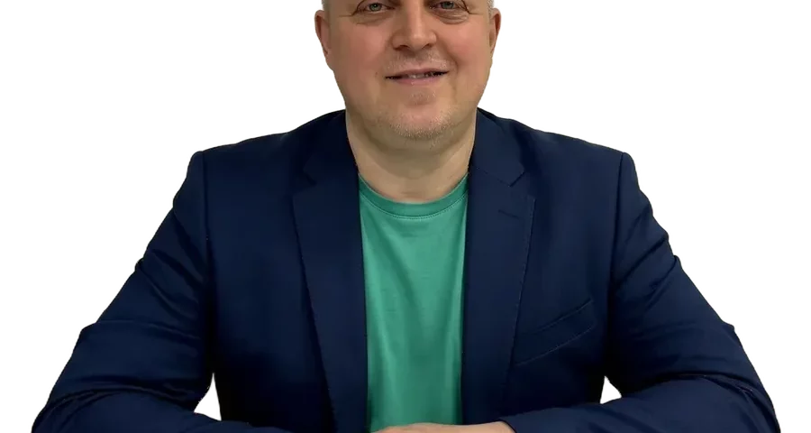Александр Макаров, медицинский психолог, улыбается за столом